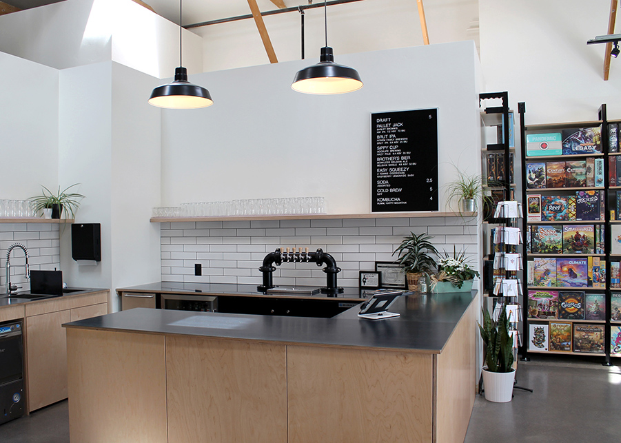 The bar area featuring white subway tiles, black countertops, and a natural wooden bar front and shelving